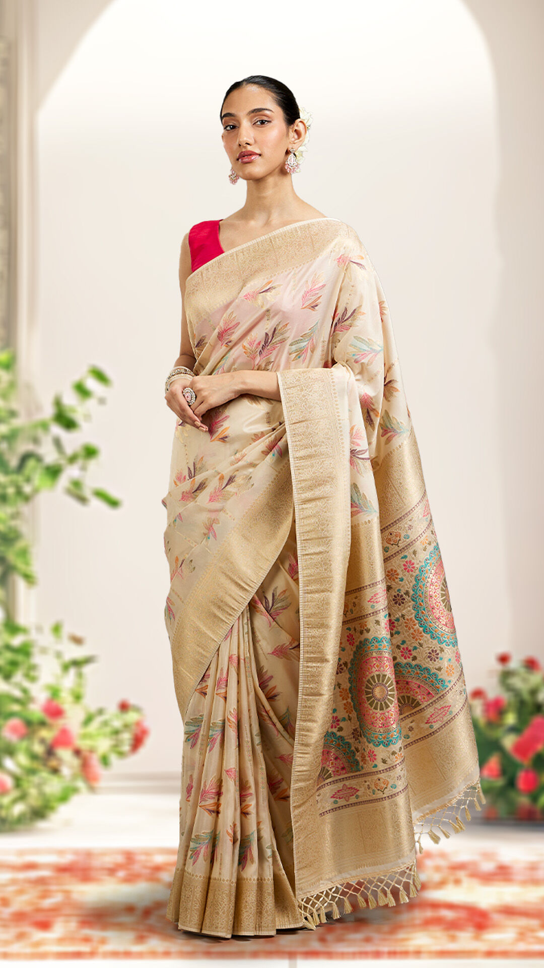 Chic woman flaunting a cream-colored floral saree paired with a modern red blouse, blending tradition with contemporary style.